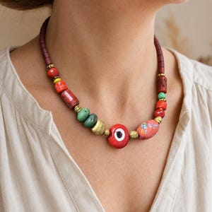 Red Evil Eye Beaded Necklace displayed on a jewelry bust, showing the necklace shape and artisan bead details
