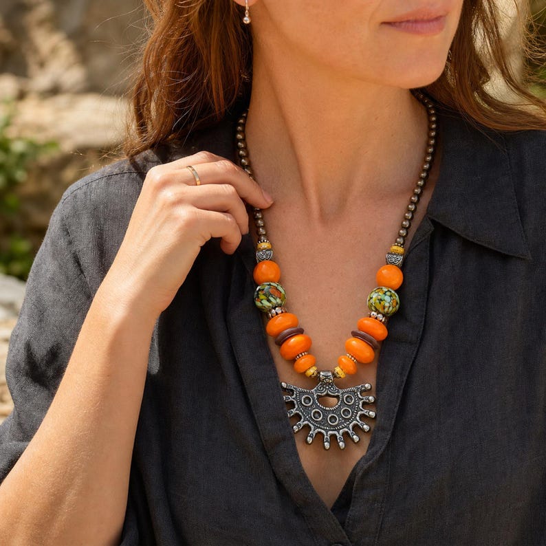Three-piece handmade necklace set featuring orange and brown beaded necklace, orange and brown beaded necklace and orange and brown beaded necklace, displayed together to show the coordinated colors and beadwork