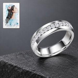 Silver-tone clear accents band on charcoal slate with restrained studio highlights on its polished edges. A personalized digital greeting card is shown alongside.