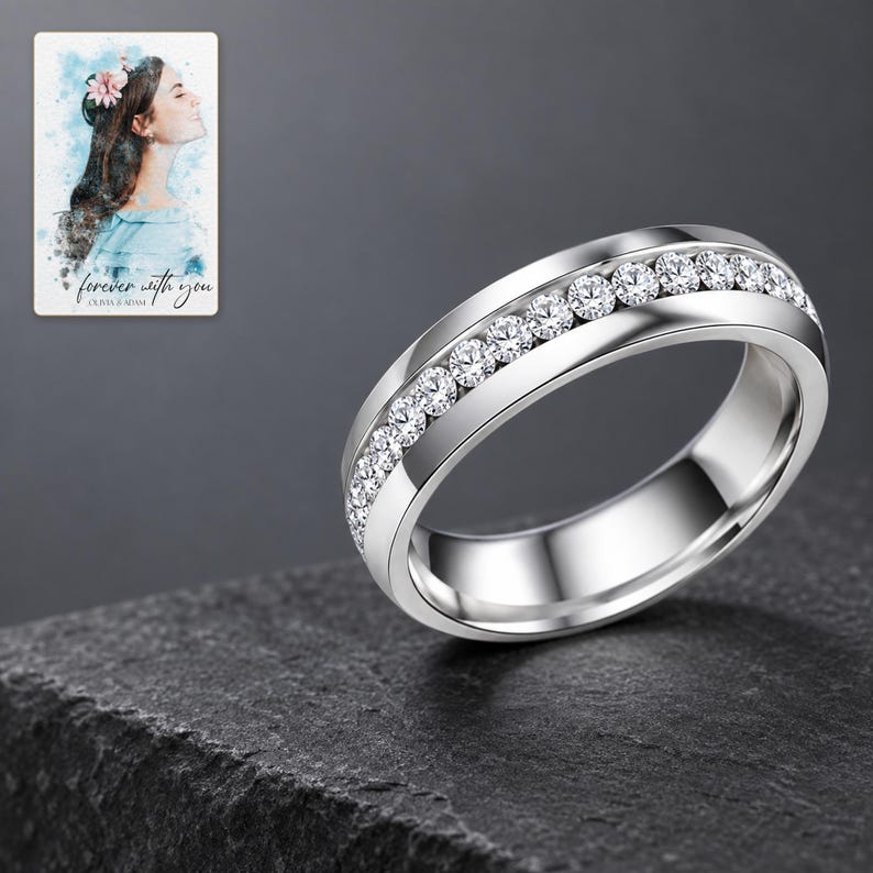 Silver-tone clear accents band on charcoal slate with restrained studio highlights on its polished edges. A personalized digital greeting card is shown alongside.