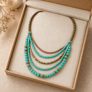 May include: A multi-strand necklace featuring turquoise-colored beads, metallic bronze-toned beads, and small gold-toned cube beads. The design includes five cascading layers of beads accented with small decorative gold-toned metal spacers.
