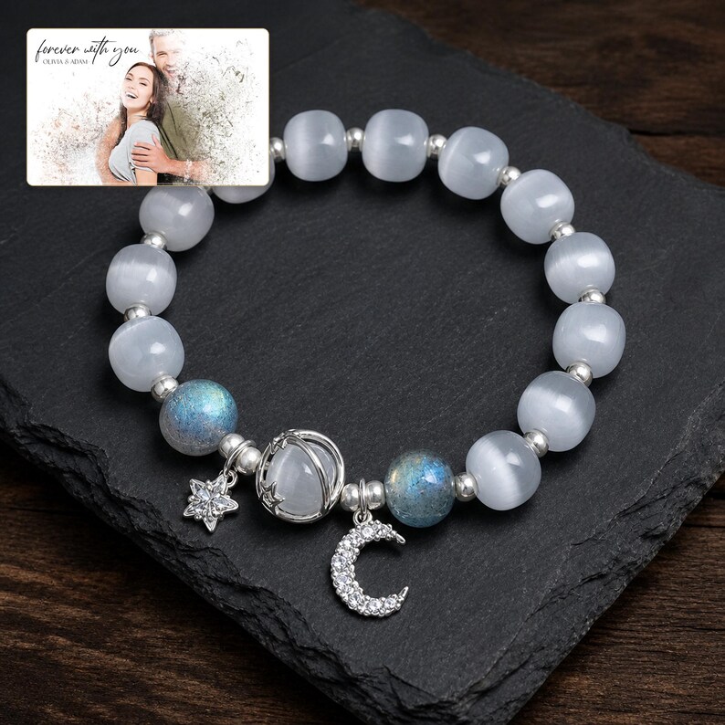 Puede incluir: Una pulsera de cuentas con cuentas blancas transl&uacute;cidas de ojo de gato, dos cuentas azules iridiscentes y espaciadores plateados. Incluye un dije de estrella plateado, un dije de media luna con piedras claras y un dije de jaula esf&eacute;rica.