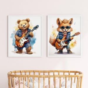 May include: Two watercolor illustrations of a bear and a fox playing electric guitars. The bear is wearing a blue denim jacket and jeans. The fox is wearing a blue denim jacket and jeans with sunglasses. Both illustrations have a watercolor background.