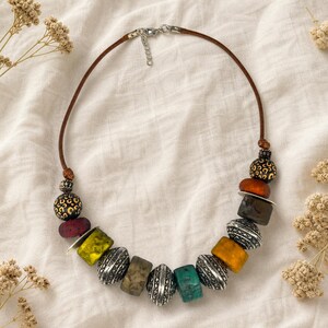 Brown and Bronze Statement Beaded Necklace presented in an open jewelry gift box on natural linen