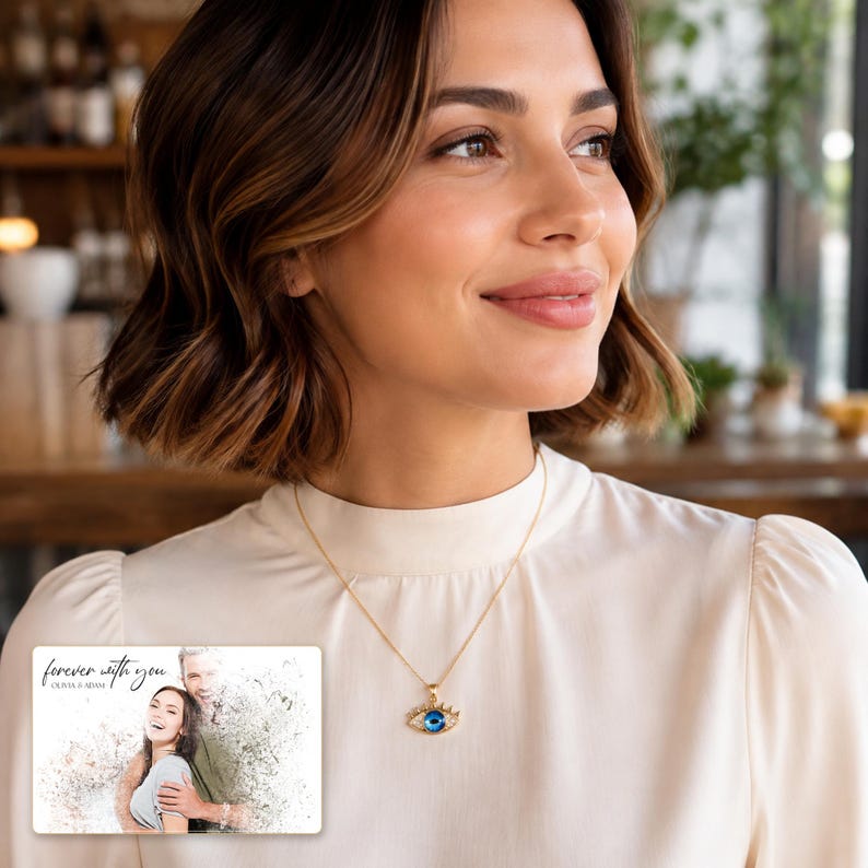 Gold-tone necklace with a blue eye-shaped pendant, adult lifestyle view. A personalized greeting-card example appears in the corner.