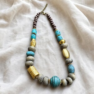 Silver and Gray Statement Beaded Necklace presented in an open jewelry gift box on natural linen