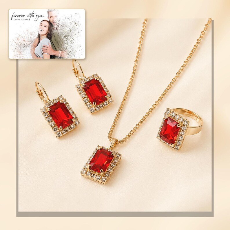 Red rectangular-stone necklace, matching earrings and ring, light-bordered product view. A personalized greeting-card example appears in the corner.