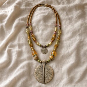Gift ready presentation of Two-tier bronze, amber and olive beaded statement necklace with layered round pendants in an open jewelry box lined with natural ivory linen
