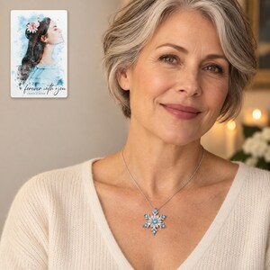 Winter Azure Snowflake Necklace worn by an adult in a polished evening lifestyle scene. A personalized digital greeting card is shown alongside.