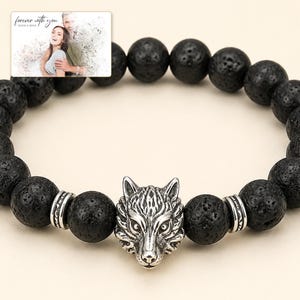 Black bead bracelet with silver-tone wolf-head detail, close detail view. A personalized greeting-card example appears in the corner.