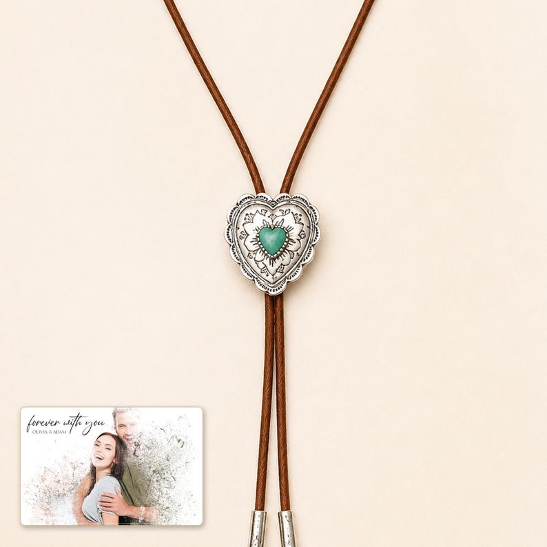 Brown cord bolo necklace with a silver-tone heart slide and turquoise-color center, close detail view. A personalized greeting-card example appears in the corner.