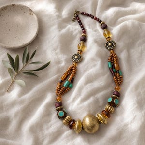 Rose Gold and Brown Statement Beaded Necklace presented in an open jewelry gift box on natural linen