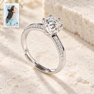 Moissanite Solitaire Ring, shown on a display surface. A sample personalized digital greeting card is shown alongside.