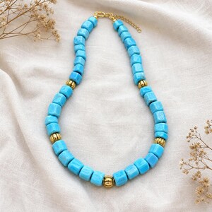 Gray and Silver Statement Beaded Necklace presented in an open jewelry gift box on natural linen
