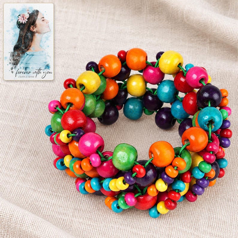 Rainbow Bead Bracelet arranged on soft ivory linen in a refined neutral flat lay. A personalized digital greeting card is shown alongside.