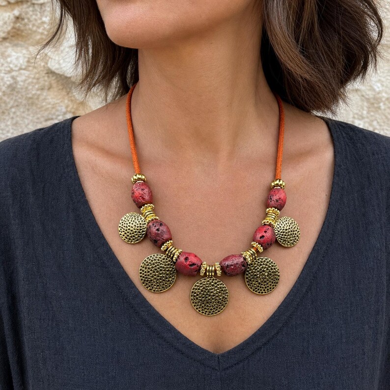 Three-piece handmade necklace set featuring red beaded coin charm beaded necklace, antique gold leaf charm beaded necklace and turquoise red beaded charm beaded necklace, displayed together to show the coordinated colors and beadwork