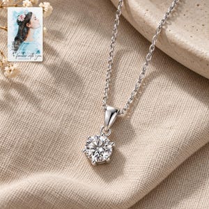 Moissanite Pendant Necklace, laid on fabric. A sample personalized digital greeting card is shown alongside.
