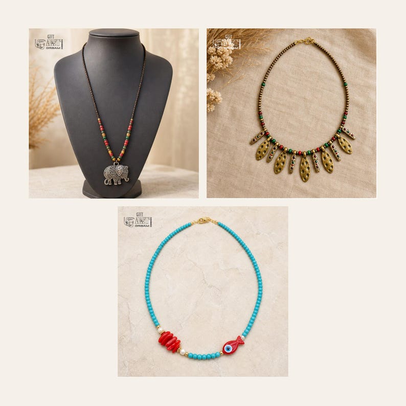 May include: Three necklaces: one with a silver elephant pendant on a beaded cord, one with gold-toned textured leaf-shaped charms and multi-colored beads, and one with turquoise beads, red coral-like segments, and a red fish-shaped charm.