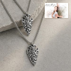 Aegis North Nordic Arrowhead Necklace photographed in warm natural window light in an elegant home setting.