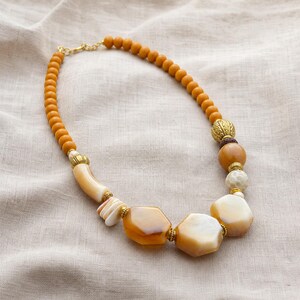 Silver and Brown Statement Beaded Necklace presented in an open jewelry gift box on natural linen