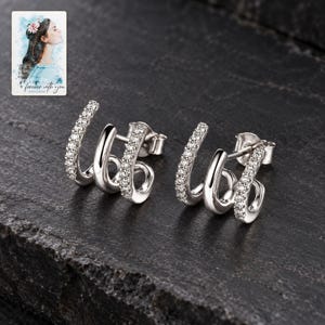 Triple Arc Stud Earrings, shown against a dark background. A sample personalized digital greeting card is shown alongside.