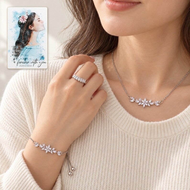 Adult woman wearing the floral necklace, bracelet and baguette-front ring with a cream knit top. A personalized digital greeting card is shown alongside.