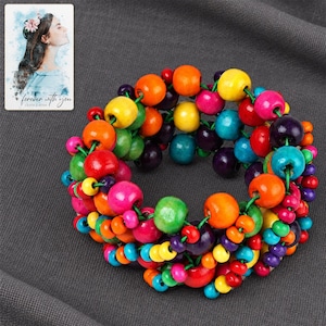 Rainbow Bead Bracelet styled against a dark luxury surface with the exact product finish clearly visible. A personalized digital greeting card is shown alongside.