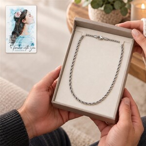 An adult receives an open jewelry styling box with the silver-tone rope chain clearly displayed. A personalized digital greeting card is shown alongside.