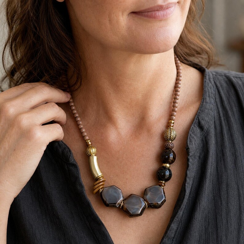 Three-piece handmade necklace set featuring brown and beige beaded necklace, purple and lavender beaded necklace and silver and brown beaded necklace, displayed together to show the coordinated colors and beadwork