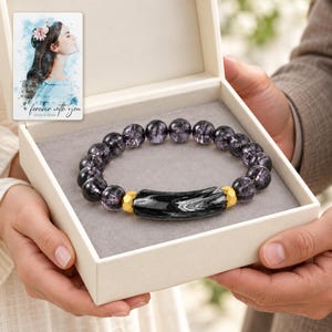 Midnight Marble Bar Bracelet shown during a believable gift-giving moment between adults with the jewelry visible. A personalized digital greeting card is shown alongside.