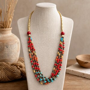 Red and Brown Statement Beaded Necklace, Boho Handmade Jewelry, Artisan Gift for Her displayed on a jewelry bust with the layered beadwork and pendants visible