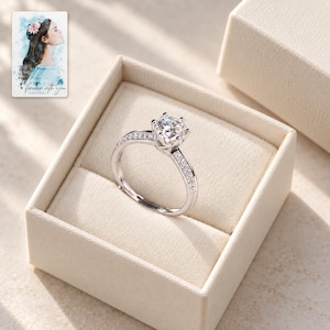 Moissanite Solitaire Ring, displayed in a presentation box. A sample personalized digital greeting card is shown alongside.