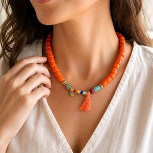 Orange and Red Statement Beaded Necklace displayed on a jewelry bust with the layered beadwork and pendants visible