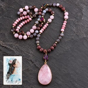 Pink teardrop pendant and mixed-color bead necklace on a dark neutral surface. A personalized digital greeting card is shown alongside.