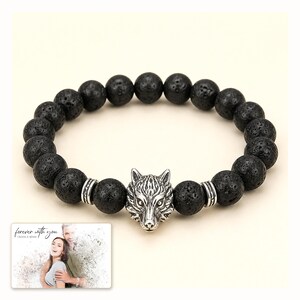 Black bead bracelet with silver-tone wolf-head detail, catalog view. A personalized greeting-card example appears in the corner.