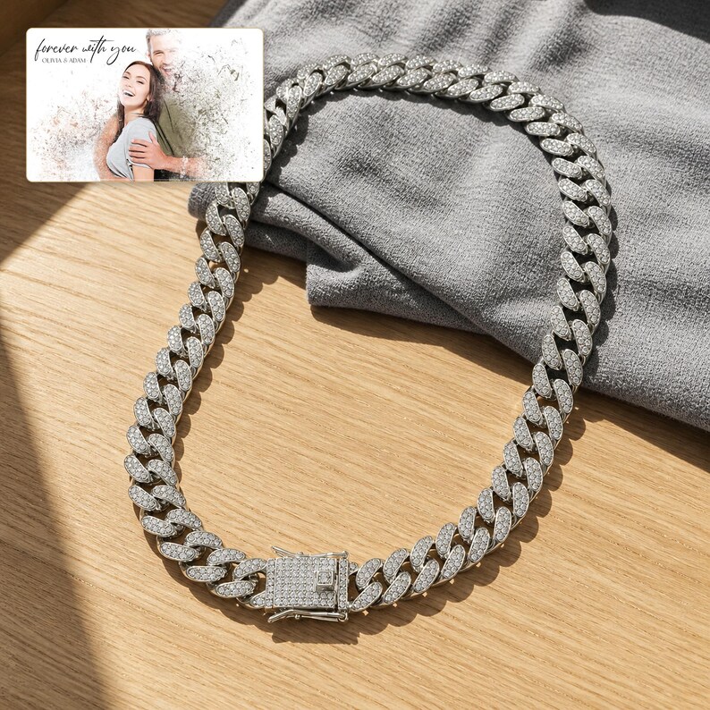 May include: A silver-toned cuban link chain necklace featuring a box clasp closure, with the entire surface of the links and the clasp encrusted with small clear stones. A small rectangular card displays a photo of a couple with the text forever with you.