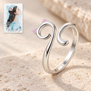 Close-up of the polished cat-head curl, pale pink ear triangles and separate smooth tail end. A personalized digital greeting card is shown alongside.
