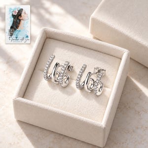 Triple Arc Stud Earrings, displayed in a presentation box. A sample personalized digital greeting card is shown alongside.
