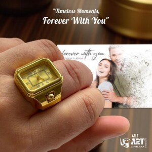 May include: A gold-colored ring shaped like a watch, with Roman numerals on the face. The ring is held by a person's hand. The image includes the text "Timeless Moments, Forever With You" and a photo of a couple.
