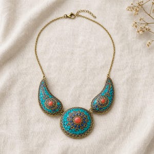 Gift ready presentation of Turquoise and coral three medallion statement necklace with antique gold chain in an open jewelry box lined with natural ivory linen
