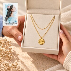 Gold Tone Coin Satellite Necklace shown during a believable gift-giving moment between adults with the jewelry visible. A personalized digital greeting card is shown alongside.