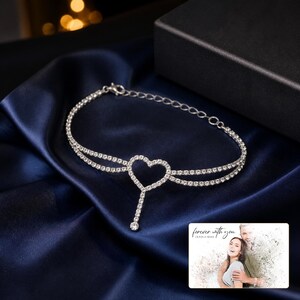 Lovelight Crystal Heart Anklet arranged on soft ivory linen in a refined neutral flat lay.
