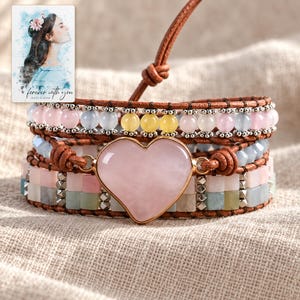 Pastel Heart Wrap Bracelet arranged on soft ivory linen in a refined neutral flat lay. A personalized digital greeting card is shown alongside.