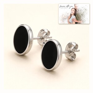 Black oval stud earrings with silver-tone edges, catalog view. A personalized greeting-card example appears in the corner.