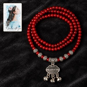 Crimson Agate style Charm Wrap Bracelet styled against a dark luxury surface with the exact product finish clearly visible. A personalized digital greeting card is shown alongside.