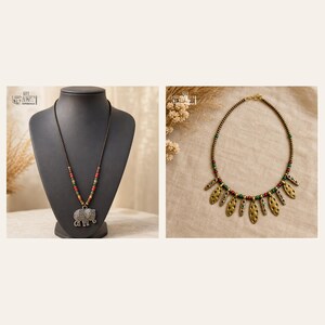 May include: A necklace featuring a silver-toned elephant pendant on a cord with red, green, and gold beads, alongside a second necklace with a series of textured, leaf-shaped gold-toned metal charms and small red and green beads.