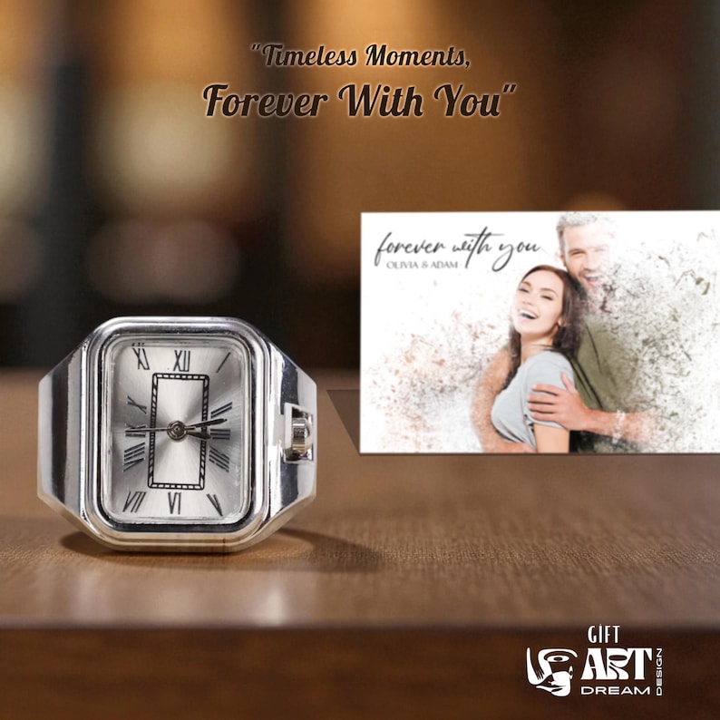 May include: A silver ring watch with a rectangular face, featuring Roman numeral hour markers and black hands. The watch is displayed next to a small print with the text "forever with you". The image also includes the text "Timeless Moments, Forever With You".