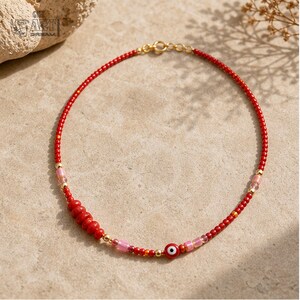 Three-piece handmade necklace set featuring turquoise beaded fish evil eye beaded necklace, red evil eye beaded necklace and red evil eye beaded necklace, displayed together to show the coordinated colors and beadwork