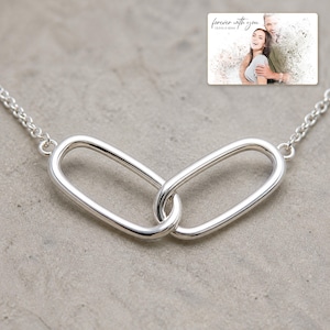Everlinked Sterling Necklace shown during a warm gift-receiving moment between adults with the exact jewelry visible.