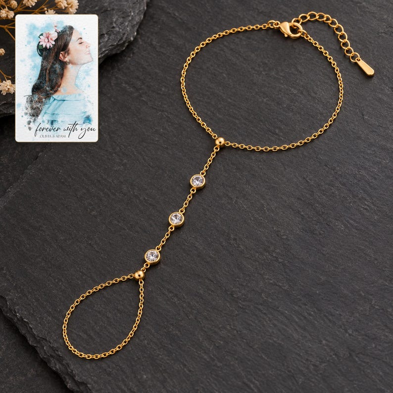 Golden Three stone style Hand Chain styled against a dark luxury surface with the exact product finish clearly visible. A personalized digital greeting card is shown alongside.